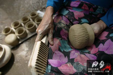 傣族木拍在陶罐上拍出花纹.jpg